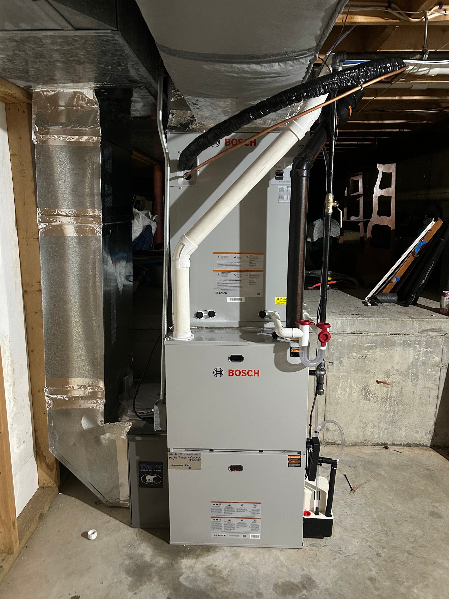 A furnace installation with a Trion whole-home air cleaner mounted alongside the return duct