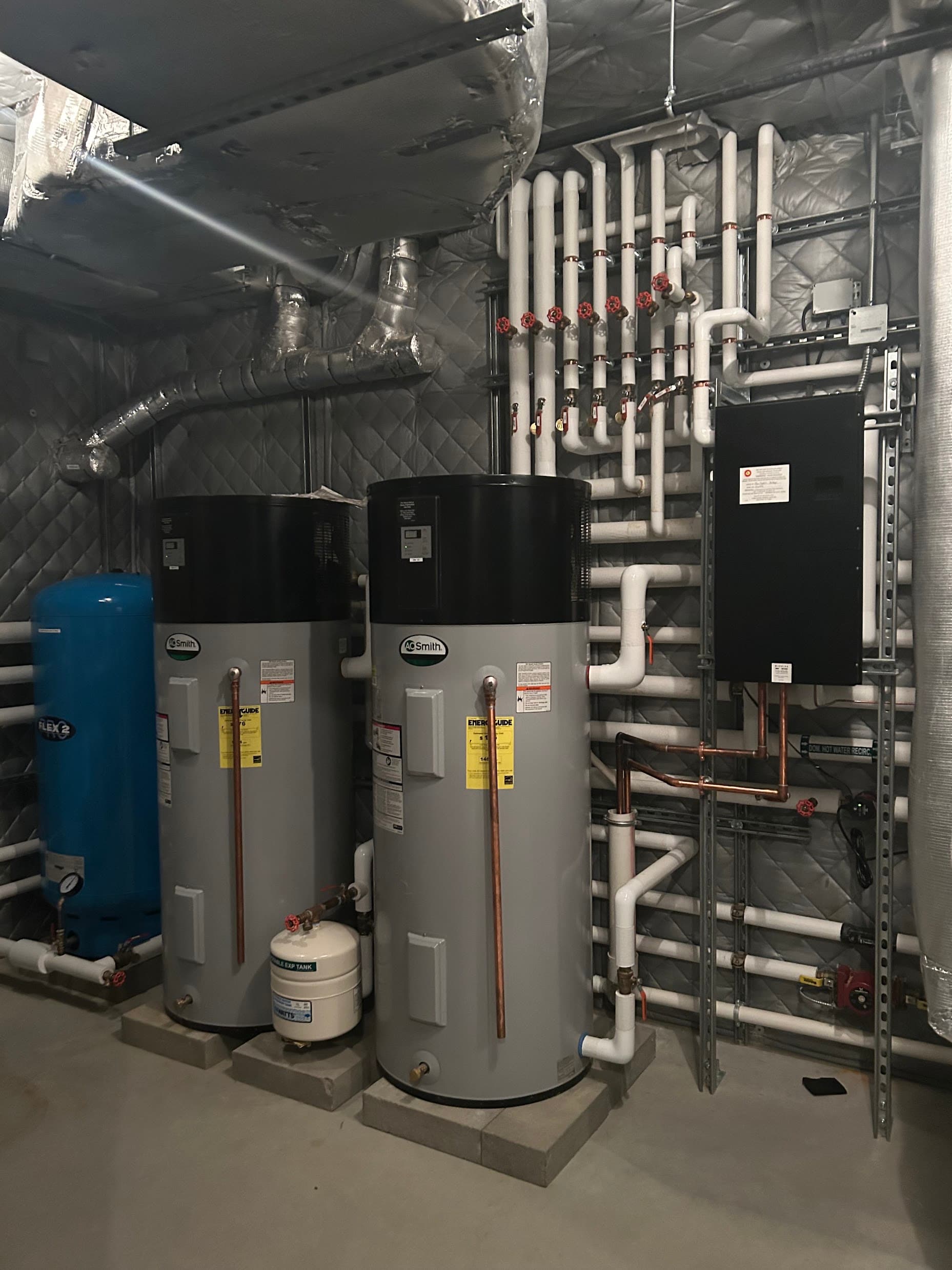 Two A.O. Smith heat pump water heaters installed in a mechanical room