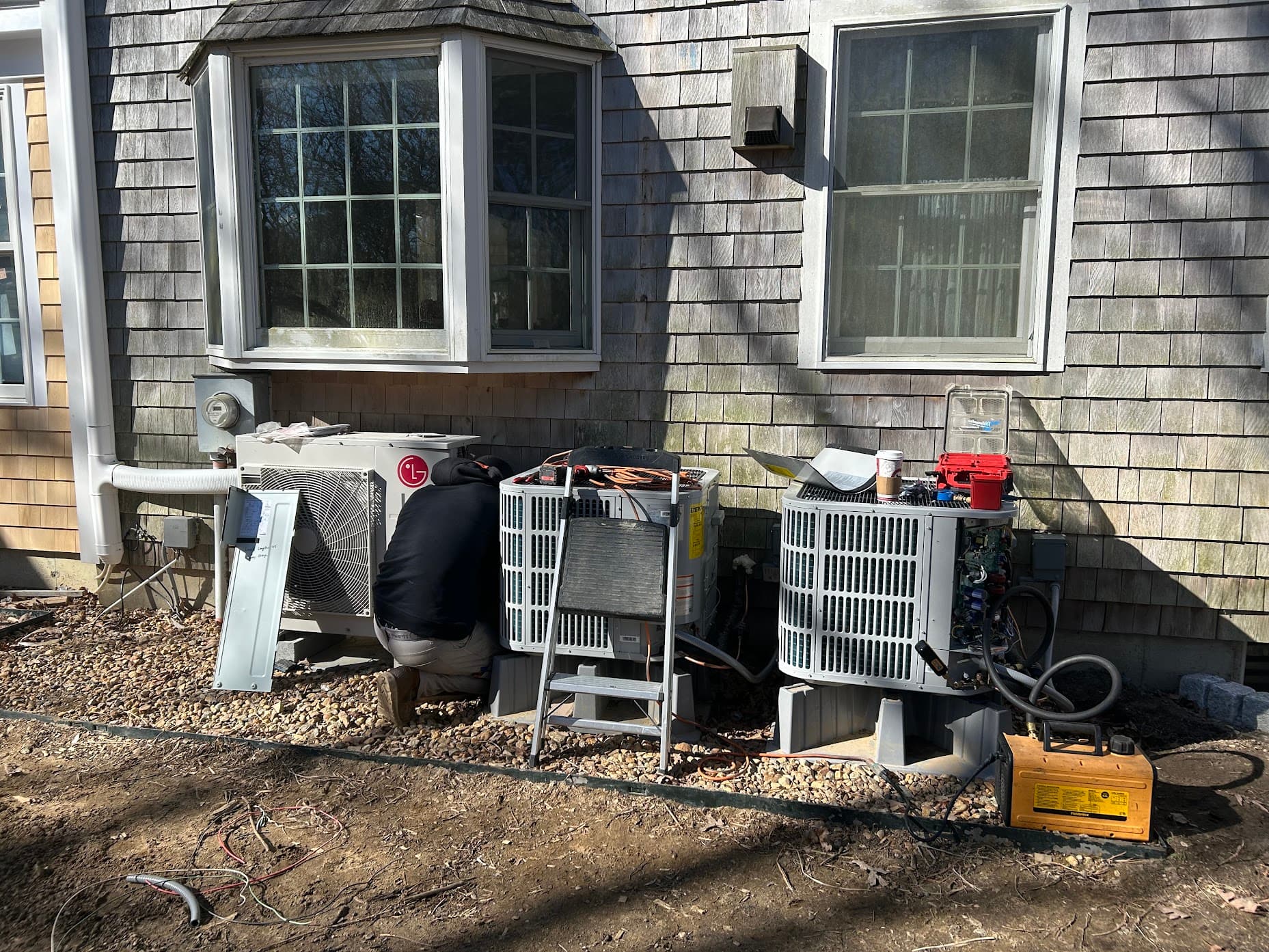 An East Coast Mechanical technician servicing outdoor condenser units